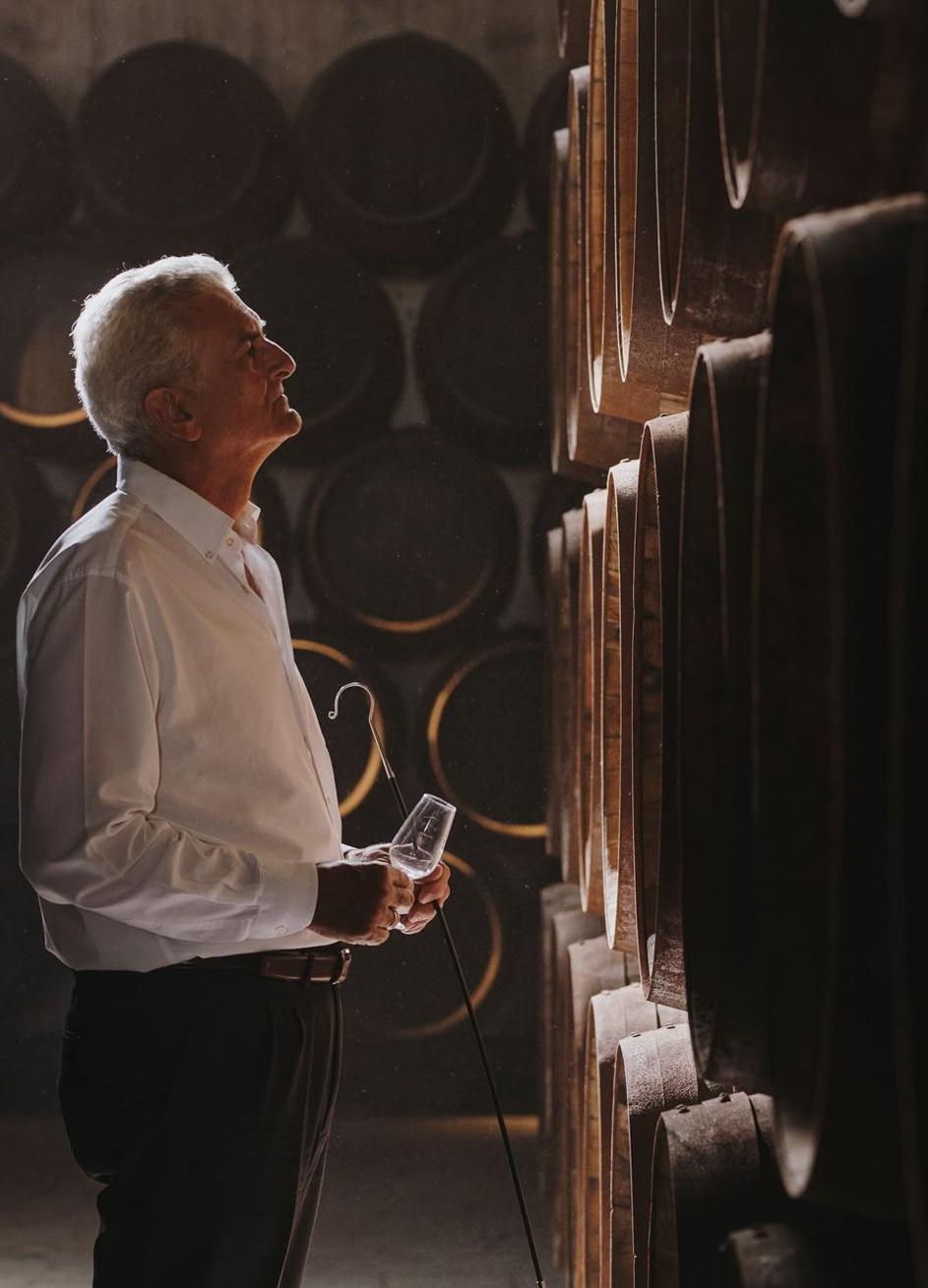 The cellar master studying barrels racked to the cellar ceiling.
